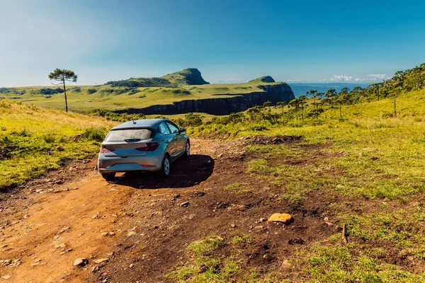 Traveling by car on a dirt road in a scenic landscape near Espraiado canyon in Santa Catarina, Brazil.