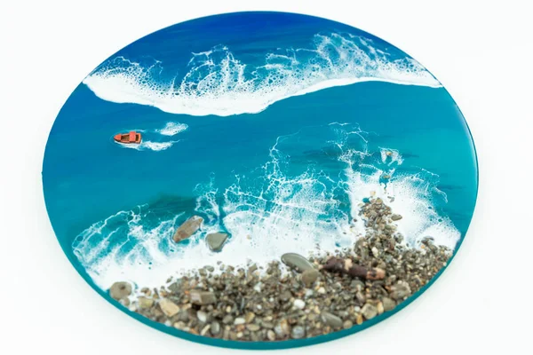 Resin art painting. Epoxy art with blue ocean waves, boat and stone beach.
