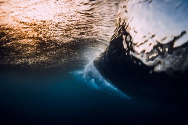 Fıçı dalgası günbatımında ya da gün doğumunda okyanusa çarpıyor. Sörf dalgalarının sualtı görüntüsü