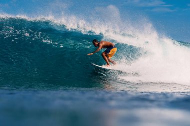 4 Ocak 2023. Bali, Endonezya. Sörf yaparken tropikal okyanusta bir adam. Sörfçü varil dalgasında sörf tahtasında.