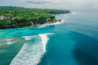 Blue ocean with waves and coastline on Padang Padang surf spot in Bali. Aerial view