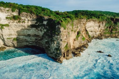 Drone view of rocky cape with forest and ocean near Uluwatu temple in tropical Bali
