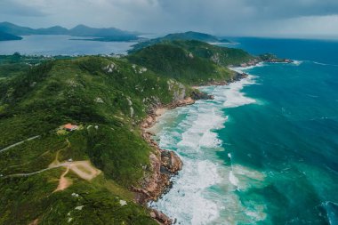 Scenic coastline with turquoise ocean and scenic cloudy sky. Aerial drone view with mountains and ocean with waves