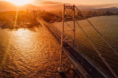 Old cable bridge with sunset light in Florianopolis, Brazil. Aerial view clipart