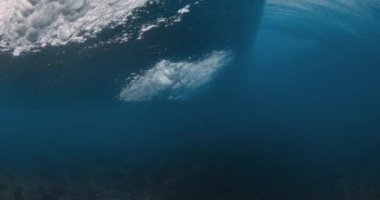 Wave crashing in blue ocean. Underwater view of surfing wave