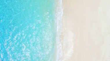 Tropical beach with white sand, turquoise ocean water, aerial view. Top view of paradise beach in tropics with blue sea
