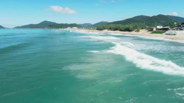Ocean waves with sandy beach in Brazil. Aerial view of Campeche beach, Florianopolis