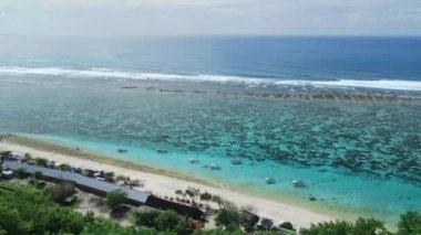 Aerial view of blue ocean and holiday beach with boats in Bali. Paradise island with tropical beach and transparent ocean water