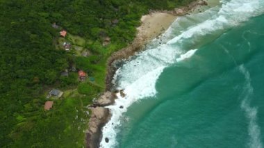 Coastline with houses, beach and ocean with waves in Brasil. Aerial view