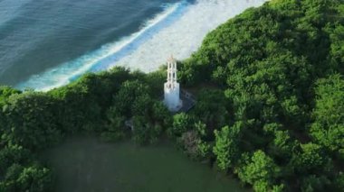 Beyaz deniz feneri ve manzaralı kıyı şeridi, Bali 'de dalgalı güneş ve okyanus manzarası