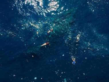 People snorkeling in plastic pollution on Liberty wreck ship in Tulamben, Bali. clipart