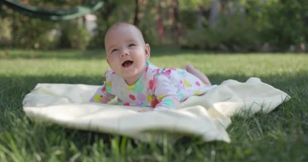 Дитяча Дівчинка Посміхається Лежить Саду Газоні Щаслива Дитина — стокове відео