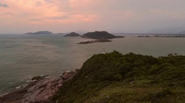 Brezilya, Santa Catarina 'da deniz feneri, gün batımı ve okyanus manzaralı bir sahil manzarası.
