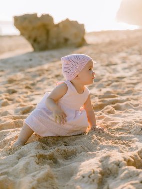 Kumsalda pembe pastel elbiseli neşeli kız.