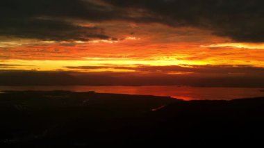 Florianopolis, Brezilya 'da bulutlar ve dağların silueti ile gün batımı veya gün doğumu. Hava görünümü.