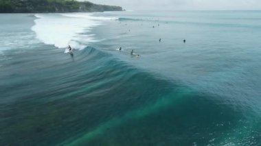 Aerial view of ocean with surfer ride on perfect wave in Bali