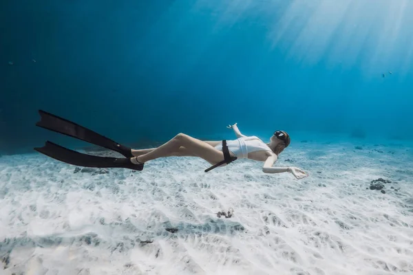 穿着白色泳衣的自由潜水女孩在热带蓝海滑翔 — 图库照片