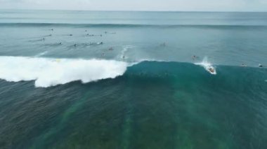 Sörfçüler Bali 'de mavi okyanusta dalgalara binerler. Hava görünümü