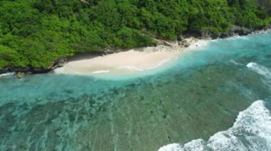 Tropical beach with turquoise ocean and waves in Bali island. Aerial view