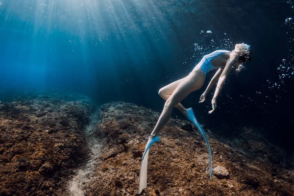 잠수부가 바다에서 속으로 광선을 받으며 아름다운 소녀와 잠수하는 — 스톡 사진