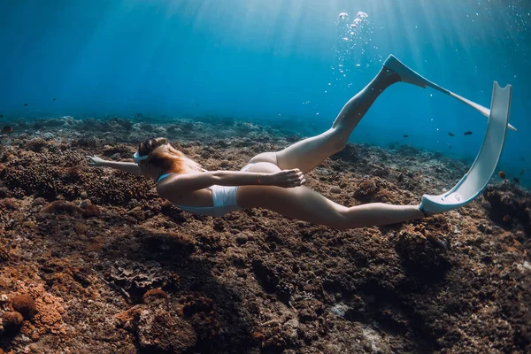女性のフリーダイバーはサンゴの上にフィンを水中で滑空 熱帯青の海でのフリーダイビング — ストック写真