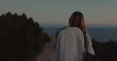 Dışarıda gün batımını seyreden çekici sarışın kadın portresi..