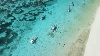 Şeffaf okyanusta balıkçı tekneleri ve güneşli bir günde tropik plajlar. Hava görünümü.