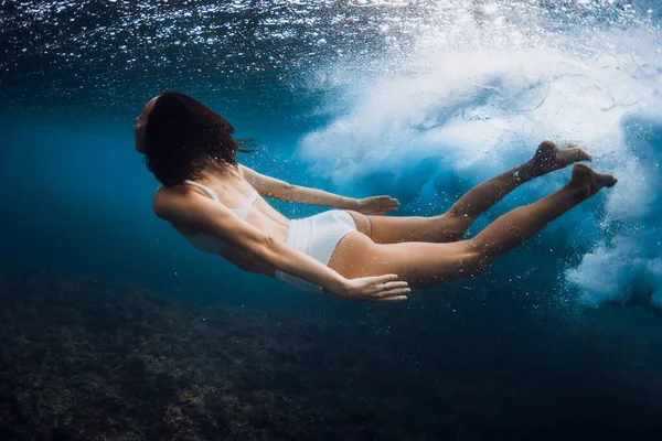 海の波で水中でサーフボードなしで泳ぐ女性 バレル波の下でアヒルのダイビング — ストック写真