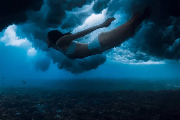 透明海の泡で力強い波を打ち破りながら泳ぐ女 ダックダイビングサーフボードなし — ストック写真