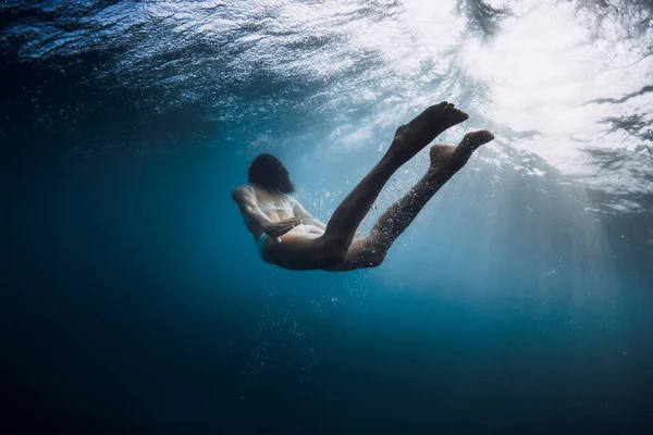 海の波と太陽の光で水中で泳ぐ女性 — ストック写真