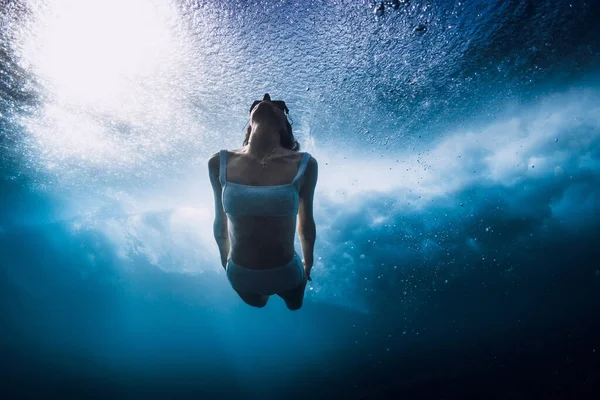 海の波で水中サーフボードなしでビキニダイビングの女性 バレル波の下で鴨の女性ダイビング — ストック写真