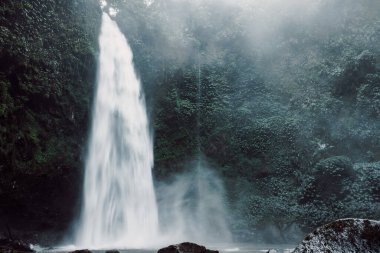 Nungnung Şelalesi Bali, Endonezya 'da güçlü bir şekilde akıyor. Tropikal doğa ve destansı şelale