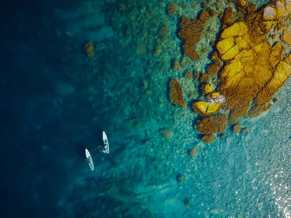 2021年5月28日 黑山布德瓦 一对夫妇站在蓝色的大海与石头桨板 在海洋中的红桨浅水船上进行娱乐活动 空中景观 — 图库照片