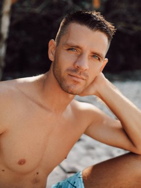 Plajdaki yakışıklı üstsüz erkek modelin seksi yakın plan portresi.