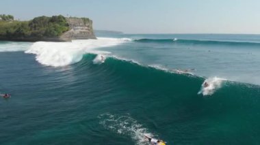 Fıçı okyanus dalgasında sörfçüler. Mükemmel mavi dalgalarda sörf yapmak