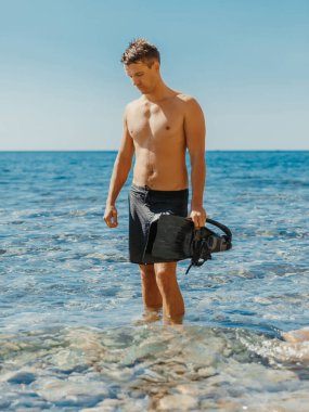 Yakışıklı sıska adam serbest dalıştan sonra sahilde eğleniyor..