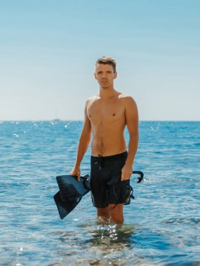 Yakışıklı sıska adam serbest dalıştan sonra sahilde eğleniyor..