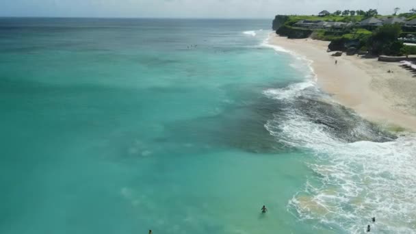 ターコイズオーシャンでサーフィン波を持つバリの休日のための人気のビーチ エアリアルビュー — ストック動画