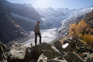 Dağlarda gezen adam. Buzul ve turist dolu bir dağ.