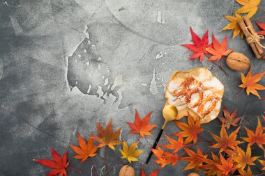 Sonbahar akçaağaç yaprakları, cevizler, elmalı pasta ve taş zeminde reçine sanat tabağı. Sonbahar Şükran Günü konsepti. Düz yatış, üst görünüm