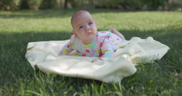 Дитяча Дівчинка Посміхається Лежить Саду Газонній Траві Щаслива Дитина Відкритому — стокове відео