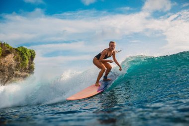 Sörf tahtasında sörf yapan kız. Sörf yaparken okyanusta bir kadın. Uzun sörfçü ve okyanus dalgası