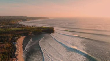 Bali 'de sıcak günbatımında mükemmel okyanus dalgaları. Büyük dalgalarda sörf yapan sahil ve kıyı şeridi..