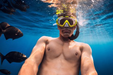 Dalış maskeli adamlar tropik okyanusta egzotik balıklarla suyun altında selfie çekiyorlar. Tropikal denizde etkinlik tatili.