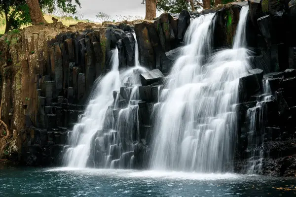 Cascade waterfall with black rocks in Mauritius island