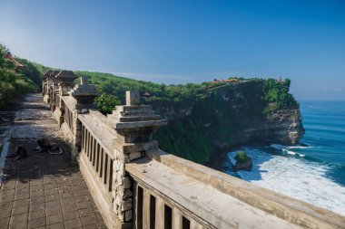 Maymunları ve bale tapınağı olan popüler bir turistik yer. Uluwatu, Bali 'de sabah ışığı ve dalgalı okyanus manzaralı uçurum.