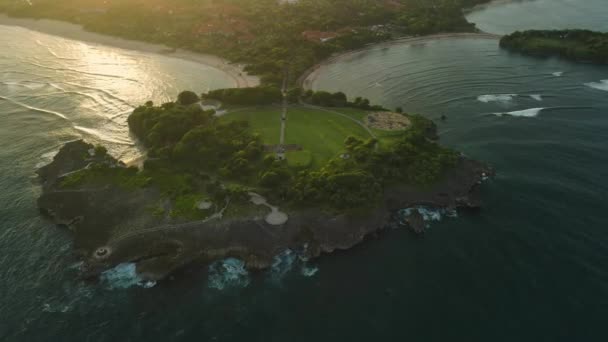 バリ島ヌサドゥアの島と暖かい日没トーンの海岸線の空中ビュー — ストック動画