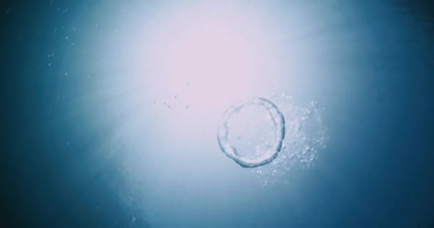 透明蓝色海洋中的水下环状气泡和太阳光 — 图库视频影像