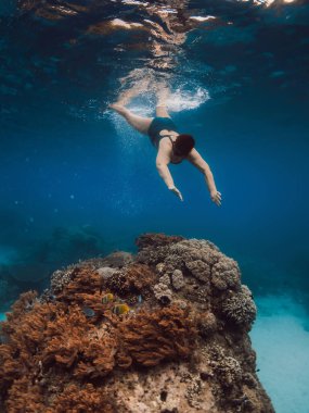 60 'ların kadın şnorkelle yüzüyor ve mavi okyanusa dalıyor. Hawaii 'de şnorkelle yüzmek