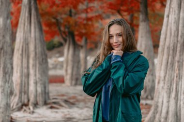Parkta yürüyen çekici genç bir kadının portresi. Güzel bayan kameraya bakıyor..
